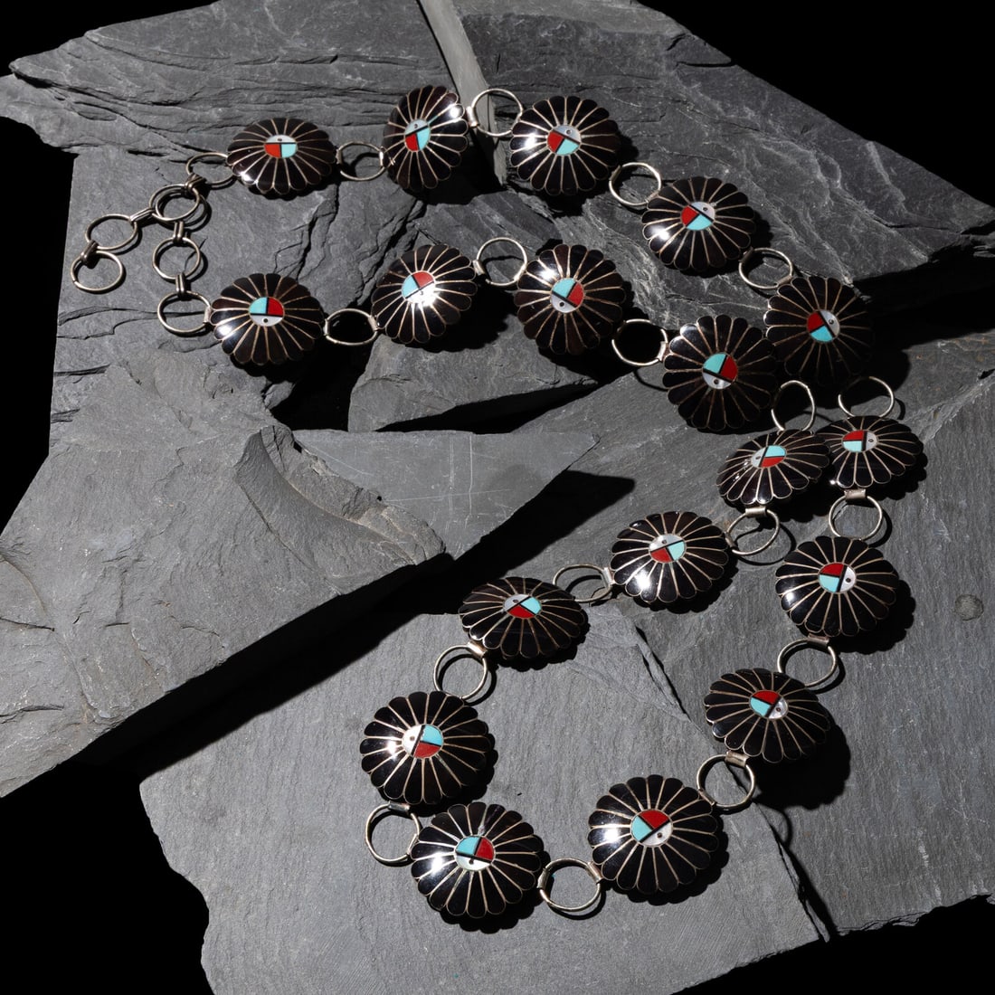 Zuni Silver and Mosaic Inlay Sunface Link Concha Belt: Zuni Silver and Mosaic Inlay Sunface Link Concha Belt 1990 eighteen conchas set with jet, shell, turquoise, and coral; signed and dated V / DICKSON ZUNI 1990 length 42 inches concha diameter 1-1/2 inc
