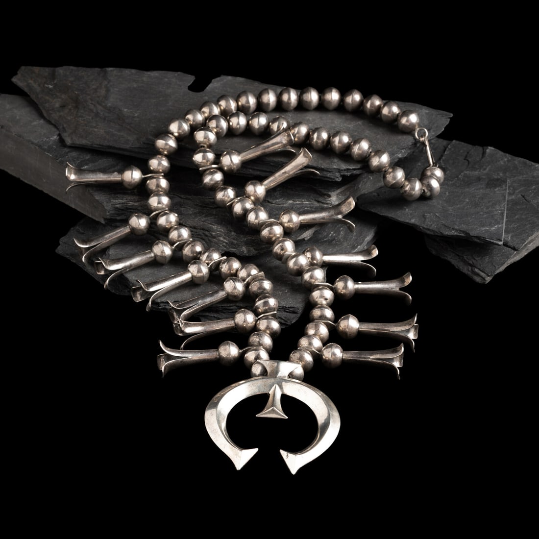 Navajo Silver Squash Blossom Necklace: Navajo Silver Squash Blossom Necklace third quarter 20th century not marked length 28-1/2 inches naja length 3 inches x width 2-1/2 inches weight 175.6 dwt. This lot is located in Chicago.