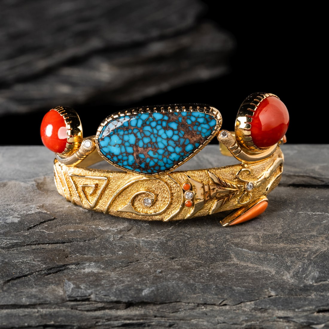 Jesse Monongya (Hopi-DinÈ, 1952-2024) Tufa Cast Yellow Gold, Coral, Candelaria Turquoise, and: Jesse Monongya (Hopi-DinÈ, 1952-2024) Tufa Cast Yellow Gold, Coral, Candelaria Turquoise, and Diamond Cuff Bracelet featuring a scrolling abstract floral motif; set with a central turquoise caboc