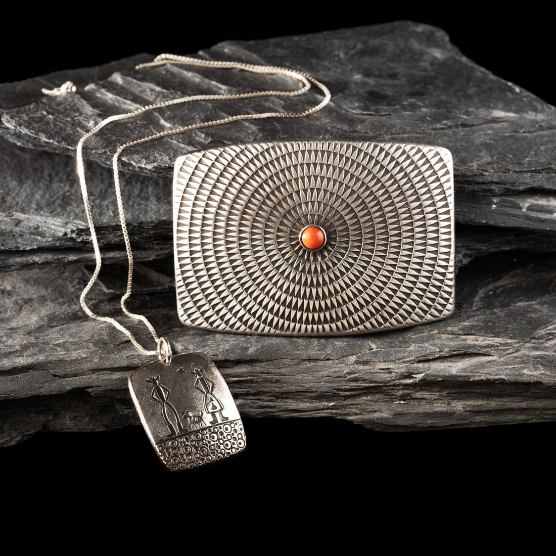 Norbert Peshlakai (DinÈ, b. 1953) Silver Belt Buckle and Pendant: Norbert Peshlakai (DinÈ, b. 1953) Silver Belt Buckle and Pendant lot of 2, both marked with artist's >o< hallmark, includes: a silver and coral belt buckle with repeating feather design hei