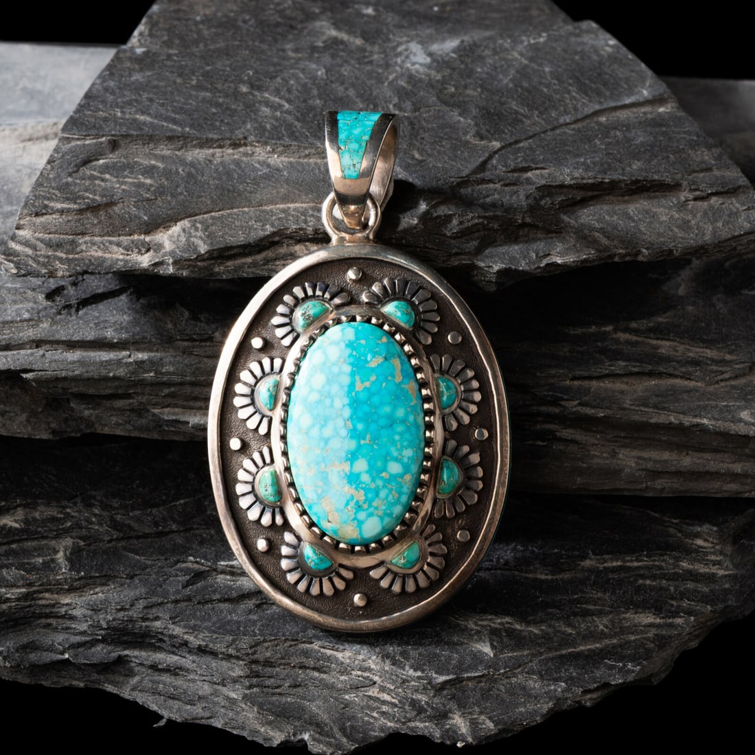 Michael Perry (DinÈ, b. 1972) Sterling Silver and Kingman Turquoise Pendant: Michael Perry (DinÈ, b. 1972) Sterling Silver and Kingman Turquoise Pendant set with a central turquoise cabochon with eight smaller stones surrounding in floral settings; further embellished wit