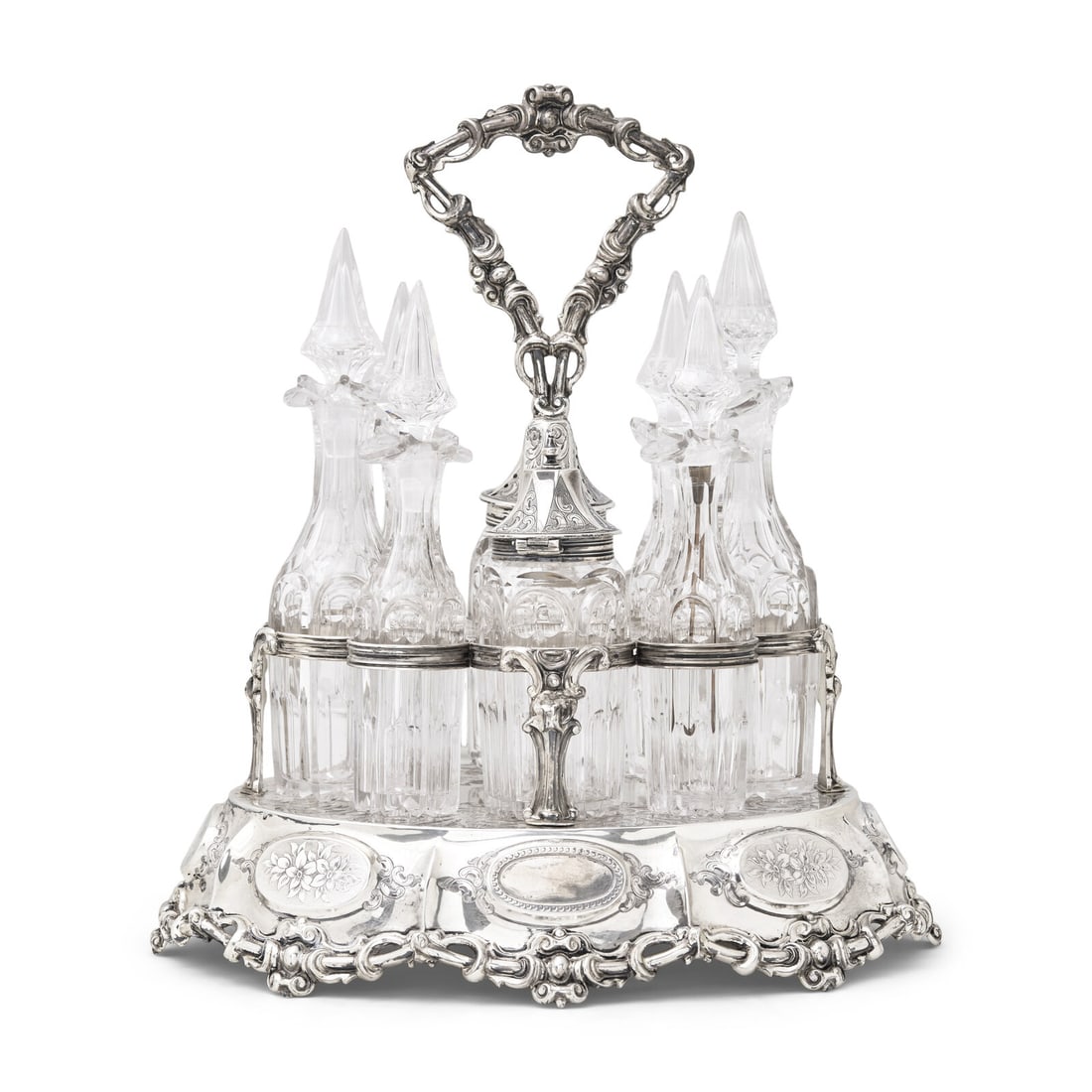 A Large and Impressive Victorian Silver and Cut Glass Cruet Set: A Large and Impressive Victorian Silver and Cut Glass Cruet Set George Angell, London, 1854 the base of lobed oval form, decorated with elaborate scrolling foliage and latticework panels, each side pa