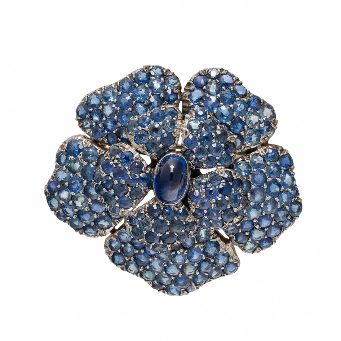 Sapphire and Silver-Topped Low Karat Gold Flower Brooch: Sapphire and Silver-Topped Low Karat Gold Flower Brooch Oval cabochon sapphire measuring approximately 8.50 x 5.90 mm, and round sapphires. Silver-topped low karat gold. 1 3/4 inches wide. Gross