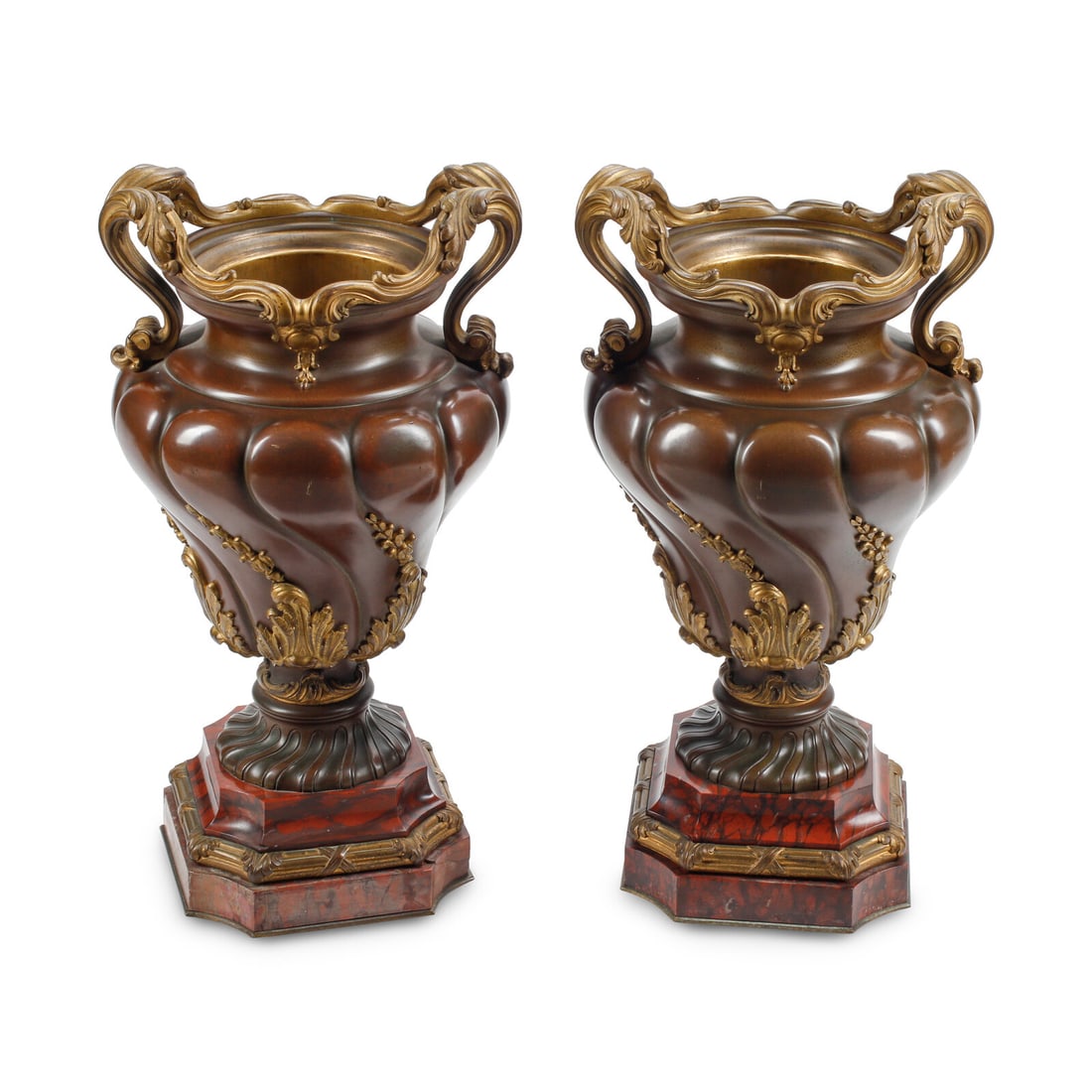 A Pair of French Patinated and Parcel Gilt Bronze Urns: A Pair of French Patinated and Parcel Gilt Bronze Urns 19th Century each raised on a marble base. Height overall 21 x width over handles 11 1/2 x depth 11 inches. This lot is located in Chicago.