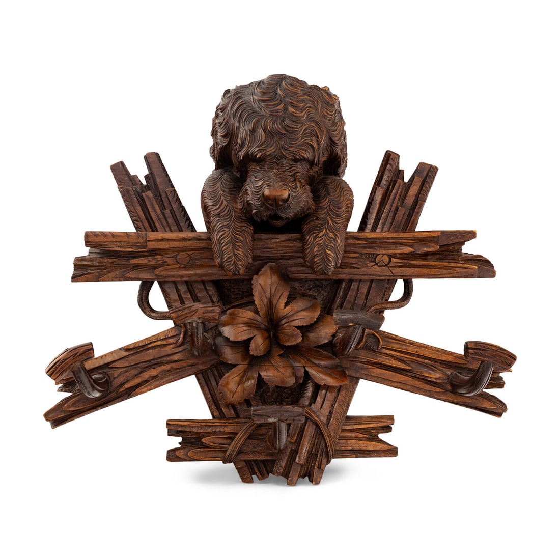A Swiss "Black Forest" Carved Figural Coat Hook: A Swiss "Black Forest" Carved Figural Coat Hook Circa 1870 modeled as a dog with his front paws over a fence and further decorated with leaves. Height 19 x width 24 x depth 8 inches. This lot is