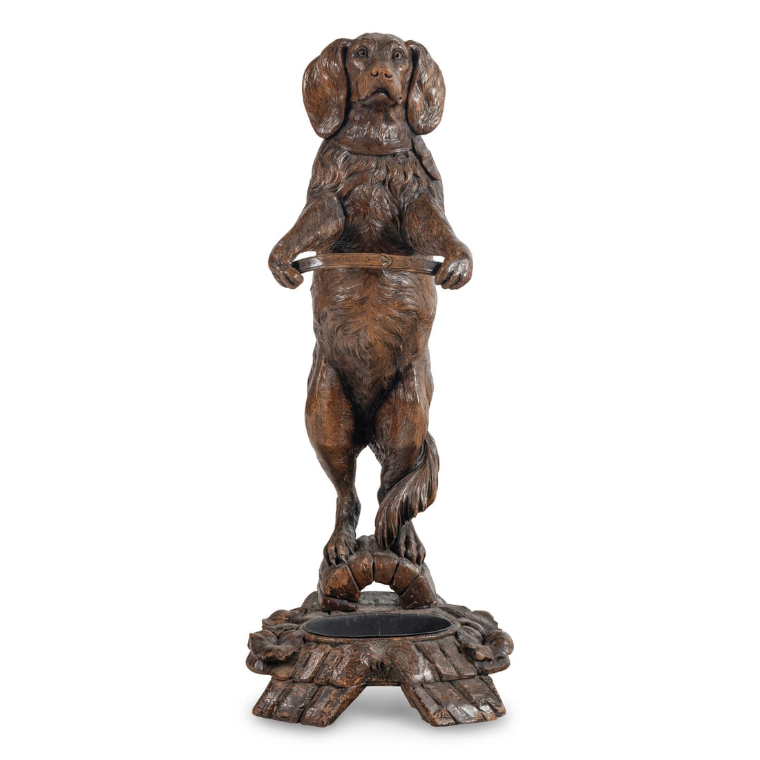 A Swiss "Black Forest" Carved Figural Umbrella Stand: A Swiss "Black Forest" Carved Figural Umbrella Stand Circa 1900 modeled as a dog standing on its hind legs holding his collar in his front paws. Height 45 x width 18 x depth 17 inches. This lot is