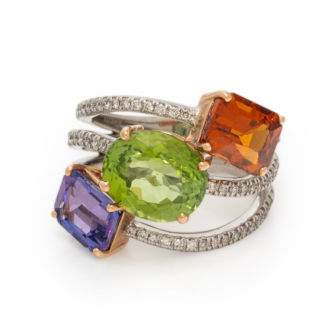 Hubert, Multigem and White Gold Ring: Hubert, Multigem and White Gold Ring Emerald cut tanzanite and spessartine garnet, oval peridot, and round brilliant cut diamonds weighing approximately 0.45 carat total. 18 karat white gold. Ring siz