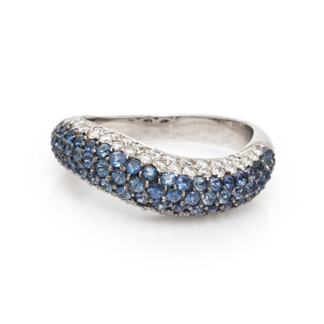Sapphire, Diamond, and White Gold Wave Ring: Sapphire, Diamond, and White Gold Wave Ring Pavé-set round brilliant cut diamonds weighing approximately 0.60 carat total and round sapphires. 18 karat white gold. Ring size 6 3/4. Stamp: 750. Gross 