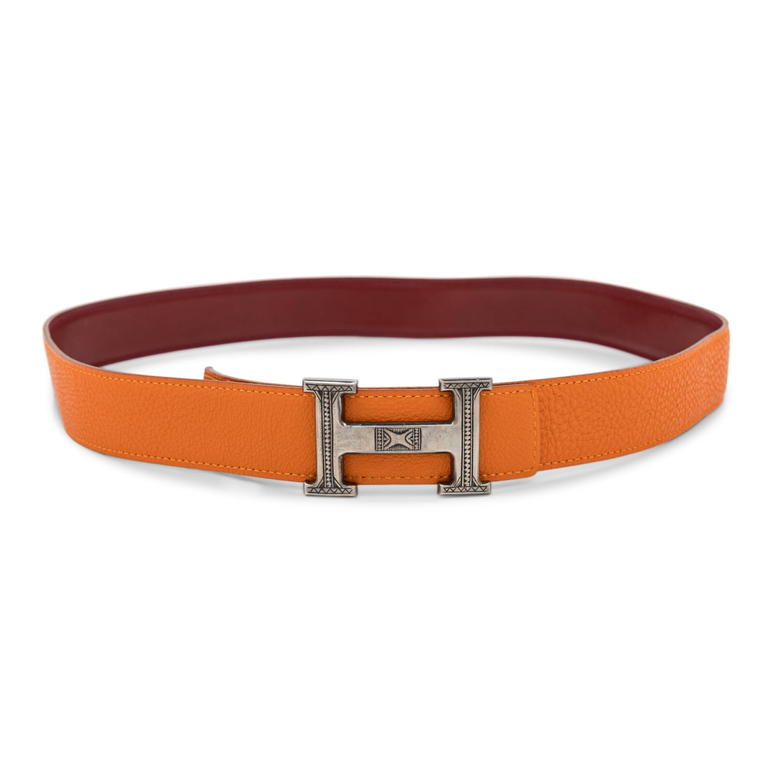 Hermès, Constance Belt with Tuareg-Engraved Sterling Buckle: Hermès, Constance Belt with Tuareg-Engraved Sterling Buckle Constance reversible belt in orange grained leather with smooth burgundy leather reverse. H buckle in sterling silver with Tuareg engraving