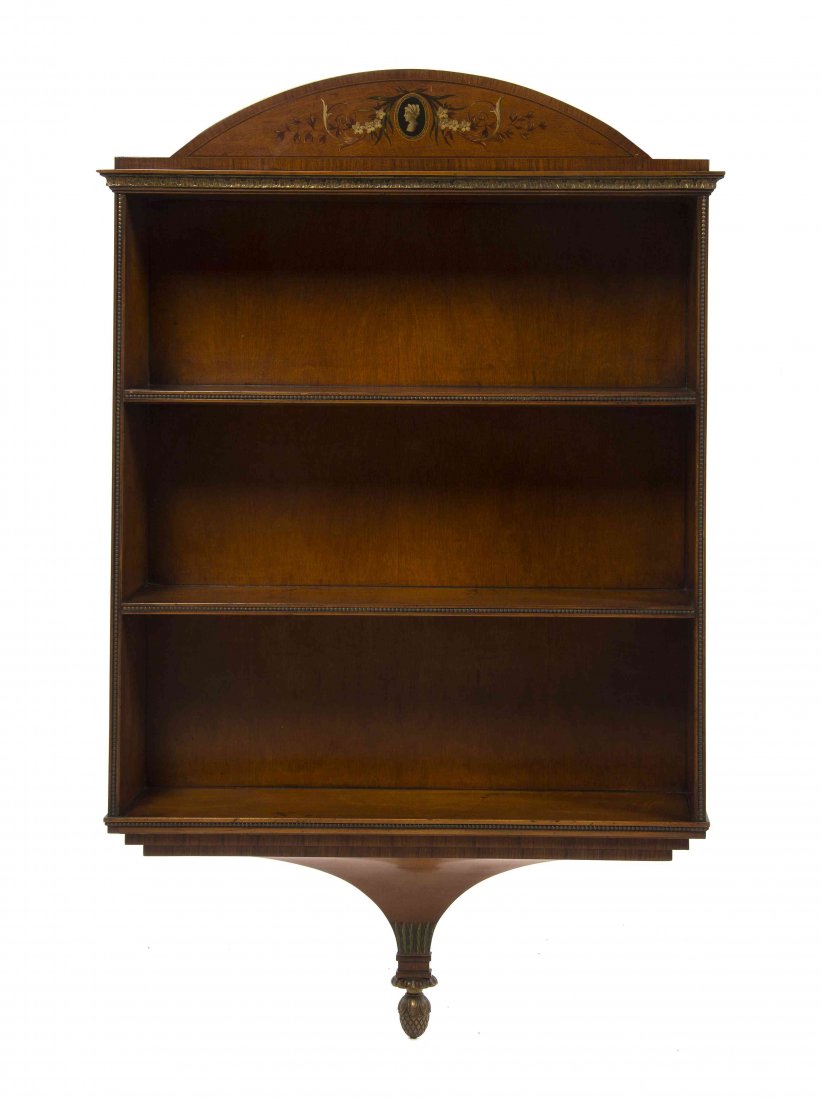 An Edwardian Satinwood Hanging Bookshelf, Height 44 1/2: An Edwardian Satinwood Hanging Bookshelf, having a domed cornice centered with a female profile over the open three shelves, ending in a pendant finial. Height 44 1/2 x width 27 x depth 7 1/4 inches.