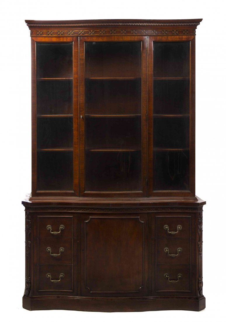 An American Mahogany Chippendale Style Breakfront: An American Mahogany Chippendale Style Breakfront Cabinet, Mount Airy, having a flared cornice over three glazed panel doors, opening to a series of shelves, the base centered with a panel door flanke