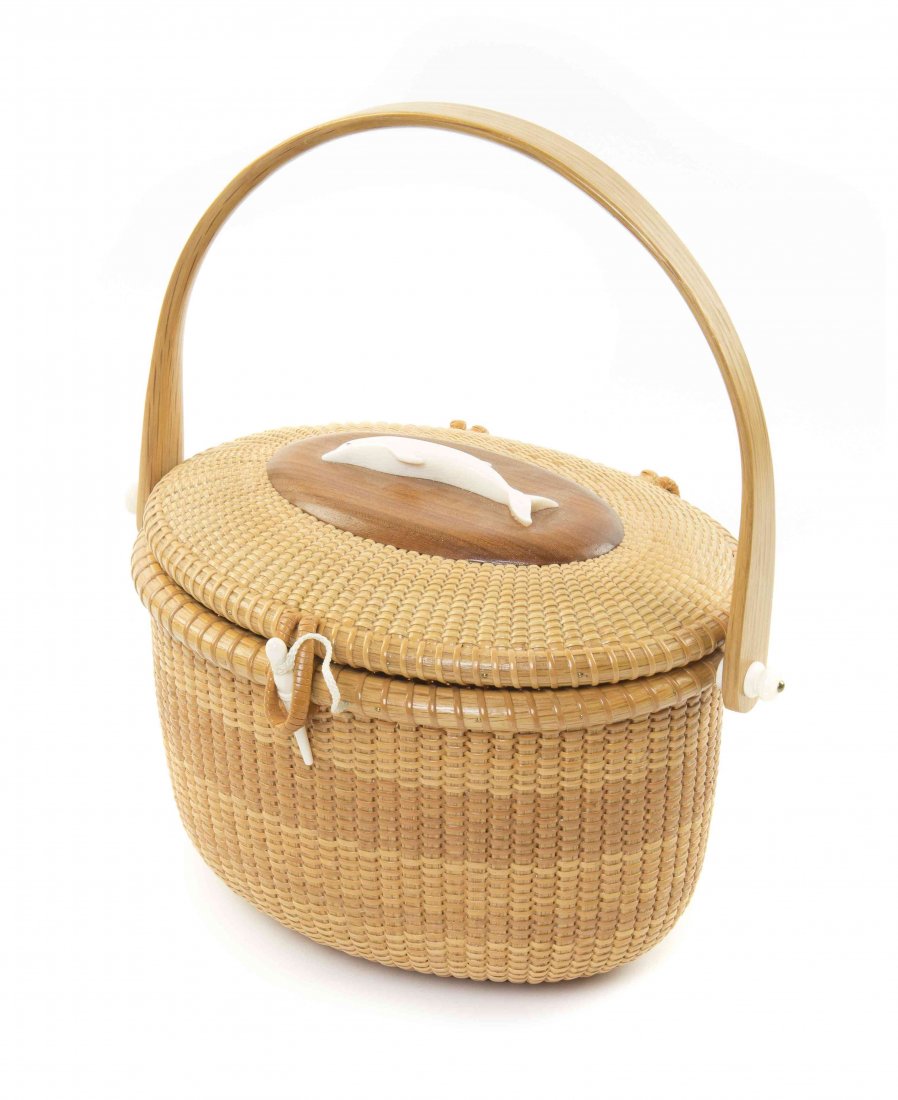 A Nantucket Basket, B & K Marks, Width 11 inches.: A Nantucket Basket, B & K Marks, of oval handled form, the lid decorated with a dolphin. Width 11 inches.
