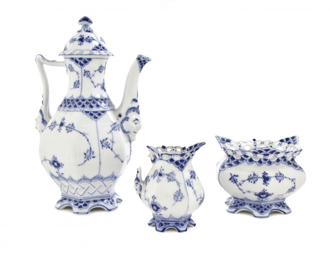 A Royal Copenhagen Porcelain Tea Service, Height of: A Royal Copenhagen Porcelain Tea Service, in the Blue Lace pattern, comprising a teapot, a creamer and an open sugar, numbered 1030, 1031, and 1112, respectively. Height of tallest 8 3/8 inches.