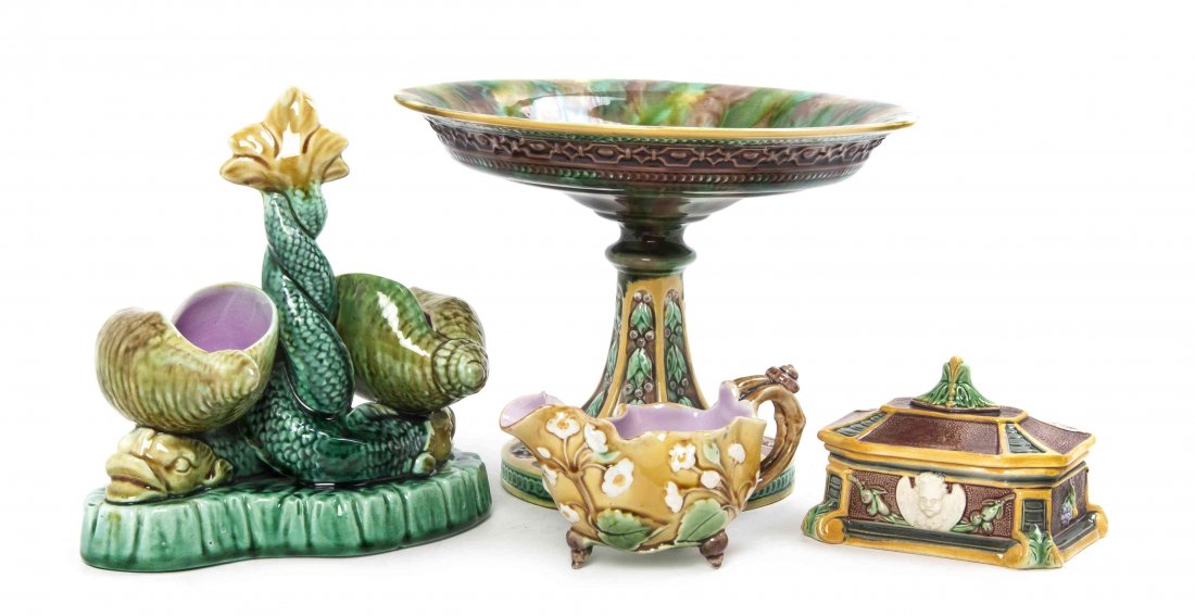 A Collection of Four English Majolica Articles, Height: A Collection of Four English Majolica Articles, comprising a compote, a covered box, a gravy and a centerpiece in the form of a dolphin with two shells. Height of first 6 1/4 inches.