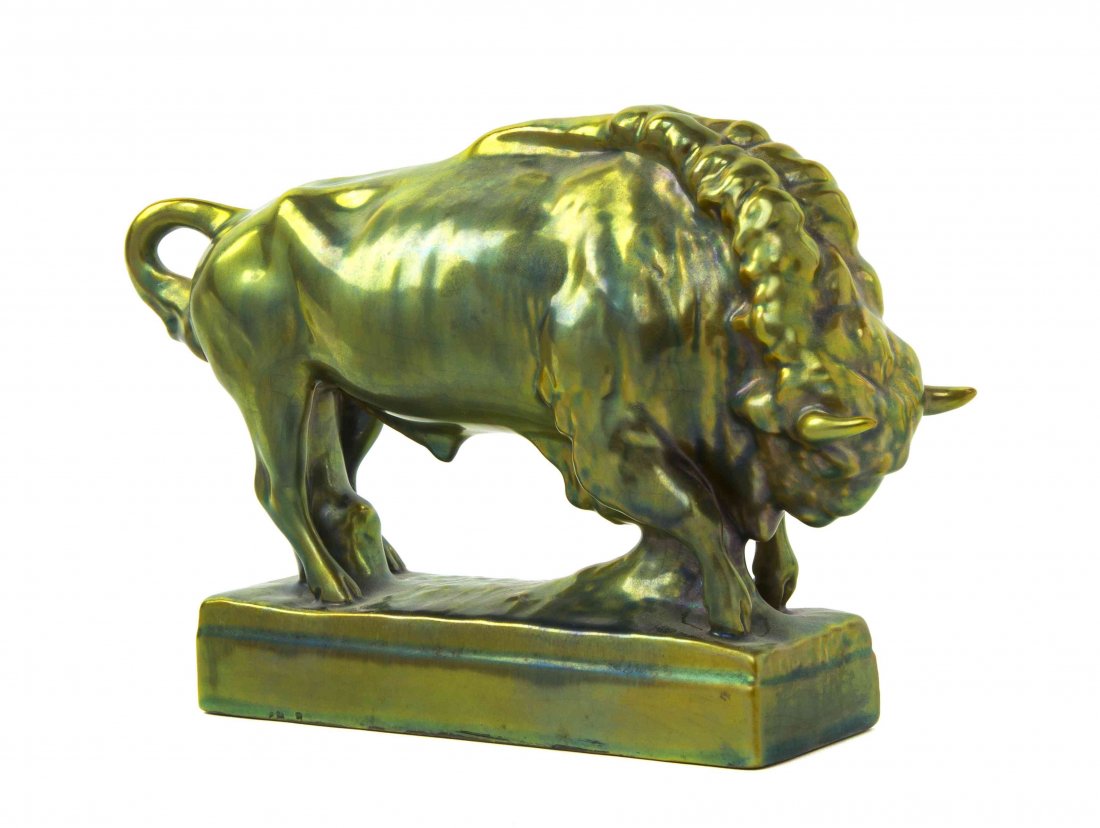 An Iridescent Glazed Animalier Figure, likely Zsolnay,: An Iridescent Glazed Animalier Figure, likely Zsolnay, depicting a charging bull, raised on a rectangular base. Width 9 1/2 inches. Property from the Estate of Grayce Haning, East Peoria, Illinois