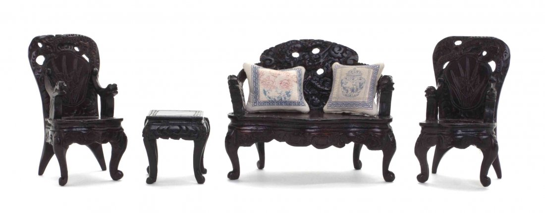 A Suite of Chinese Style Rosewood Furniture, Width of: A Suite of Chinese Style Rosewood Furniture, comprising a settee and two armchairs having carved dragon and iris decoration, and a matching end table, each retaining a tag to underside declaring From 