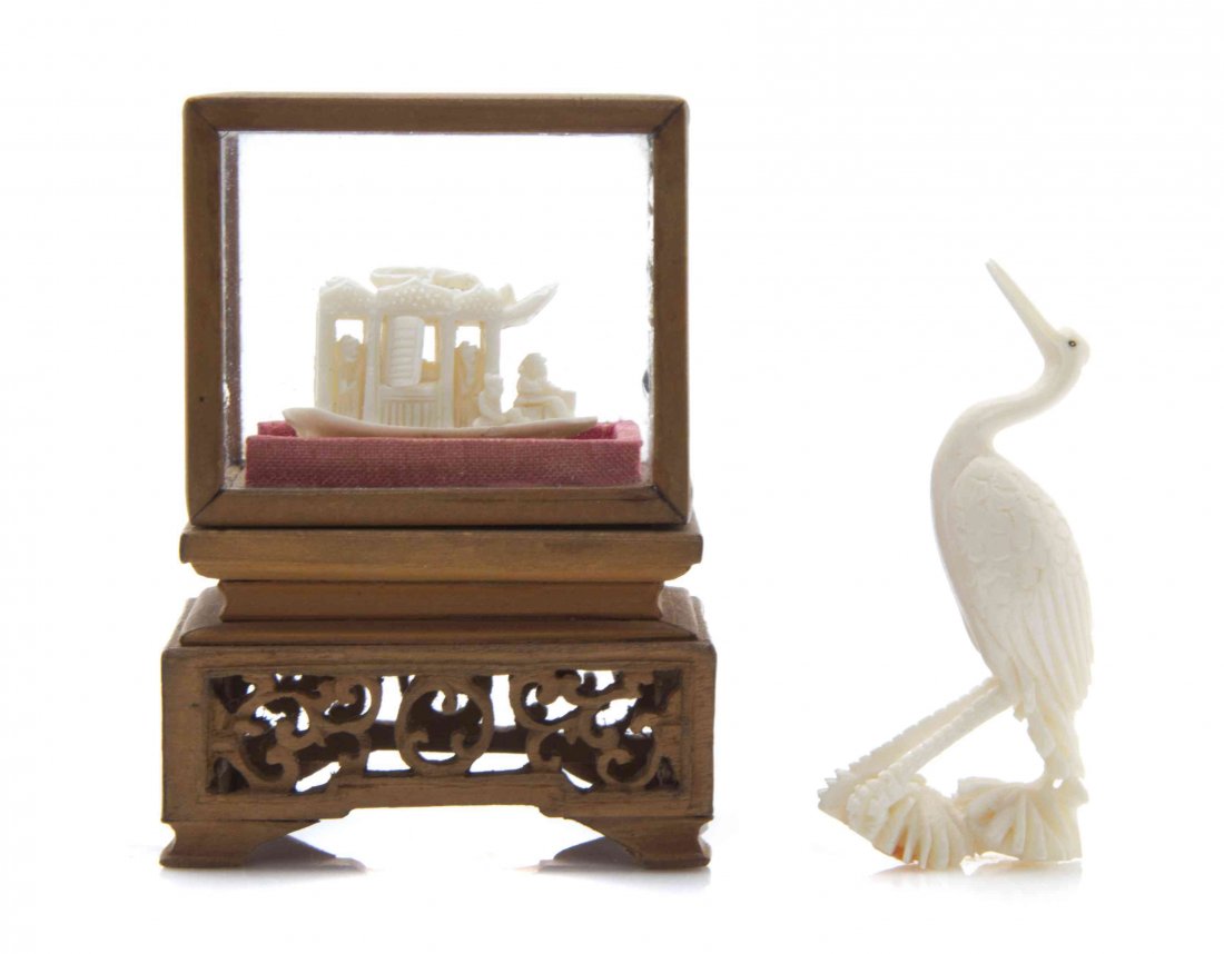 Two Chinese Carved Ivory Articles, Height of case: Two Chinese Carved Ivory Articles, comprising a boat, having free-moving windows, displayed in a carved wood case, and a figure of a crane. Height of case overall 2 1/2 inches. The Adell Venus Collect