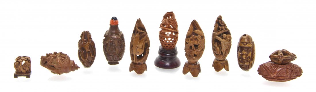 A Group of Eleven Chinese Carved Fruit Pits, Height of: A Group of Eleven Chinese Carved Fruit Pits, each having relief-carved decoration depicting various scenes. Height of tallest 1 7/8 inches. The Adell Venus Collection of Miniatures Property from the E