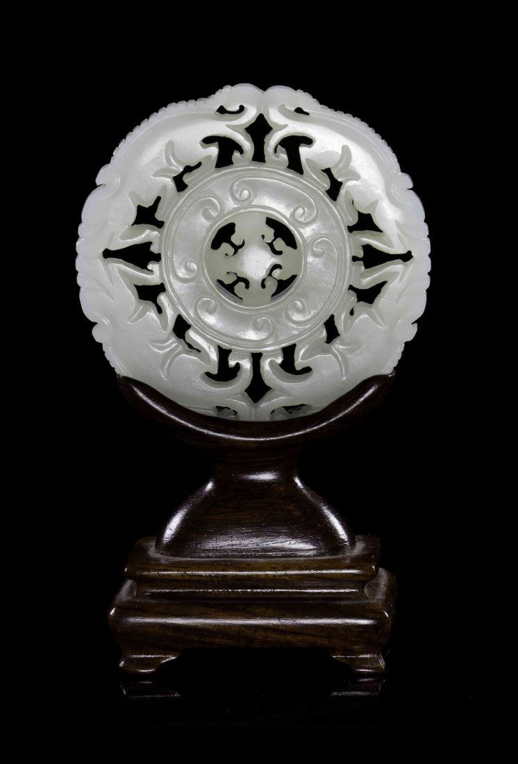 A Carved Jade Disc, Diameter 2 3/8 inches.: A Carved Jade Disc, of a near-white stone, the outer border depicting two pairs of opposed four-legged beasts around a bi with raised C-scrolls around a center with pierced carved lingzhi fungus forms