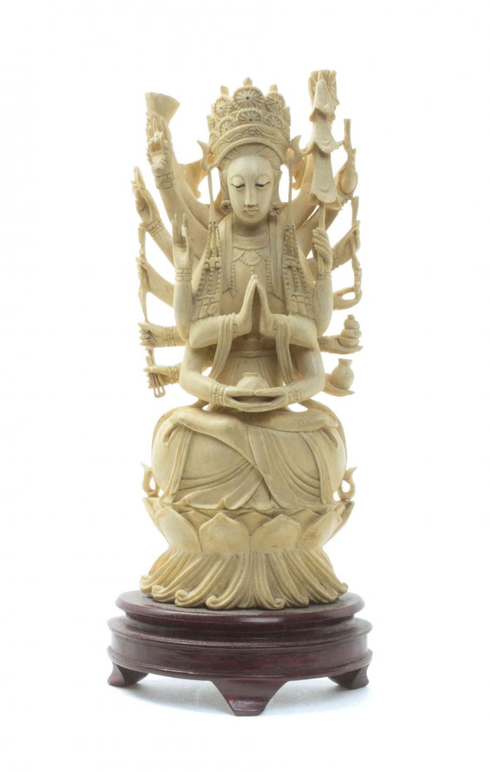 A Sino-Tibetan Carved Ivory Figure of an Eighteen-Armed: A Sino-Tibetan Carved Ivory Figure of an Eighteen-Armed Deity, the Buddhist figure depicted wearing a tiered crown and necklace, bearing various attributes including a dharma wheel, canopy, hatchet, v