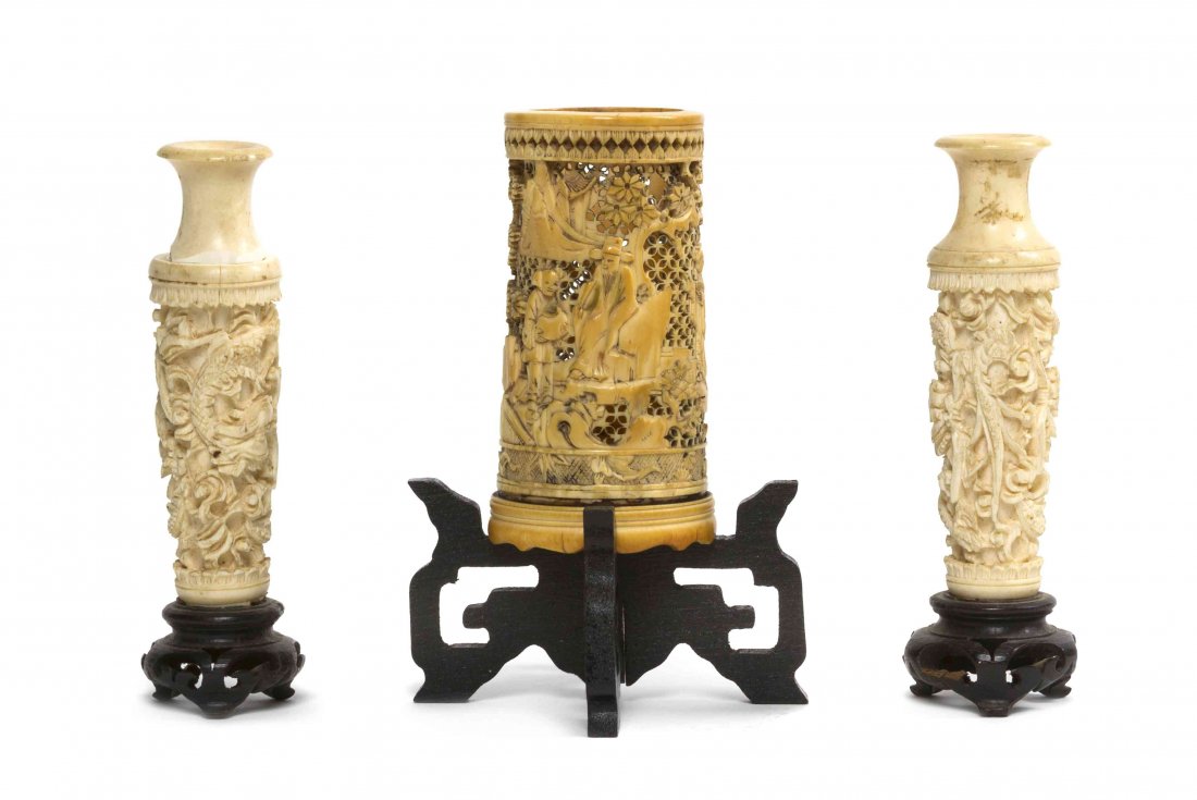 A Chinese Pierce Carved Ivory Pen Holder, Height of: A Chinese Pierce Carved Ivory Pen Holder, together with a pair of ivory baluster vases, each raised on a hardwood stand. Height of taller 3 1/2 inches. Property from the Estate of Mr. Frank Buttram, O