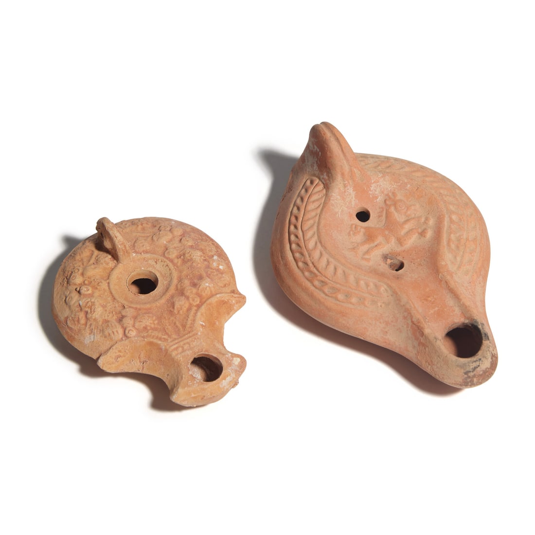 Two Late Roman Terracotta Oil Lamps: Two Late Roman Terracotta Oil Lamps Circa 5th-6th Century A.D. Length of largest 13.5 cm (5 1/4 inches). Property from Allyson Averell, New Jersey This lot is located in Chicago. Provenance: Richard C