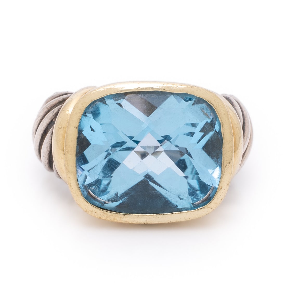 David Yurman, 'Noblesse' Blue Topaz, Sterling Silver, and Yellow Gold Ring: David Yurman, 'Noblesse' Blue Topaz, Sterling Silver, and Yellow Gold Ring Checkerboard faceted cushion cut blue topaz measuring approximately 13.80 x 11.80 x 7.90 mm. Sterling silver and 14 karat yel