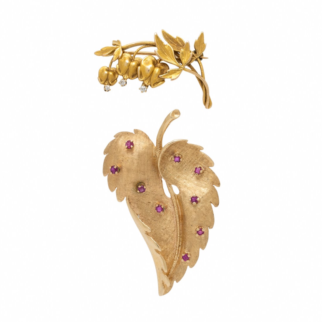 Two Yellow Gold Foliate Brooches: Two Yellow Gold Foliate Brooches One leaf brooch set with round rubies, and one floral brooch set with old European cut diamonds. 14 karat yellow gold, and yellow gold. 2 inches wide. 1 1/4 inches wid