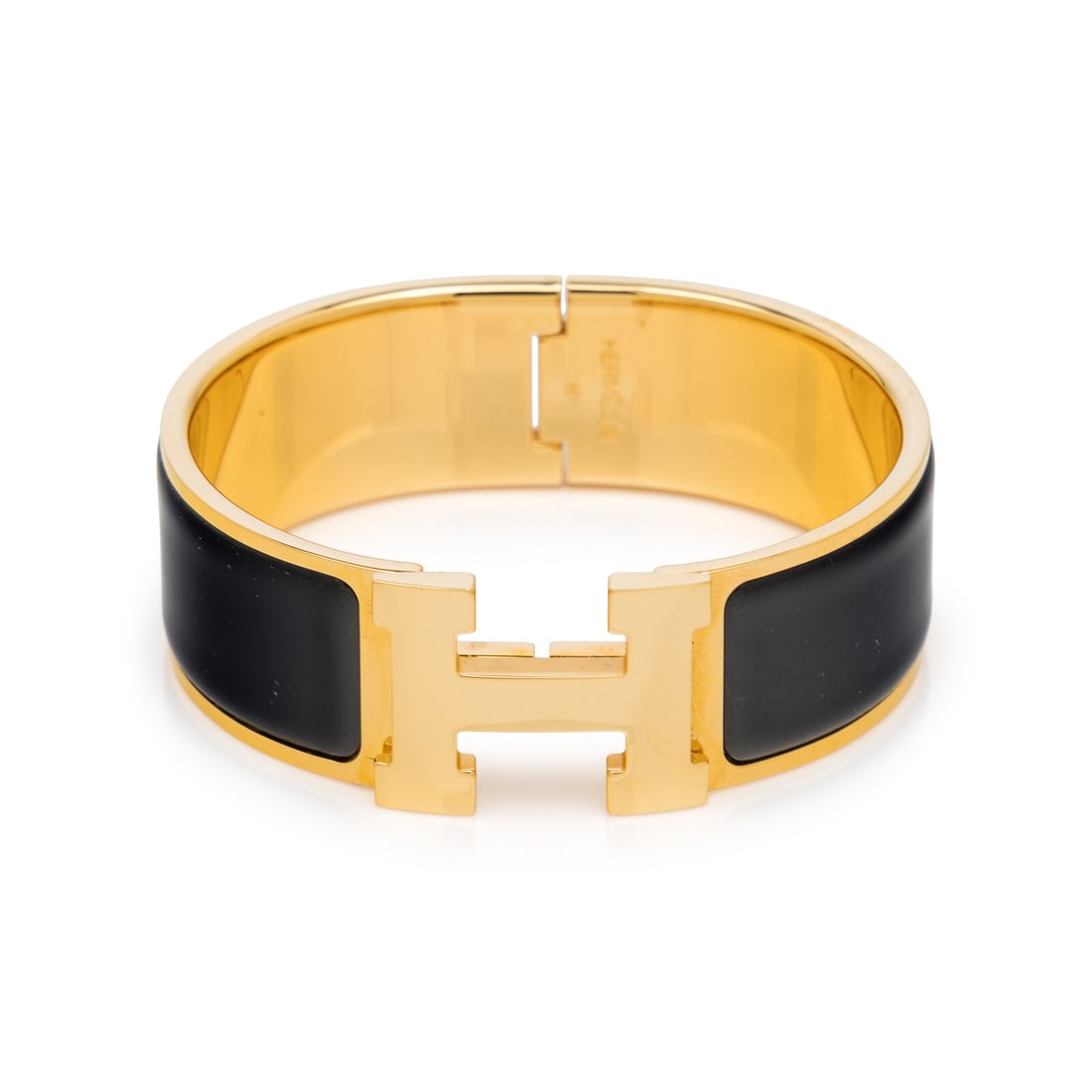 Hermès, Clic Clac H Bracelet: Hermès, Clic Clac H Bracelet Clic Clac H bracelet in gold-tone metal with black enamel details. Turn-lock H closure. Label: Hermès Country of Origin: France Approximate Measurements: Inner