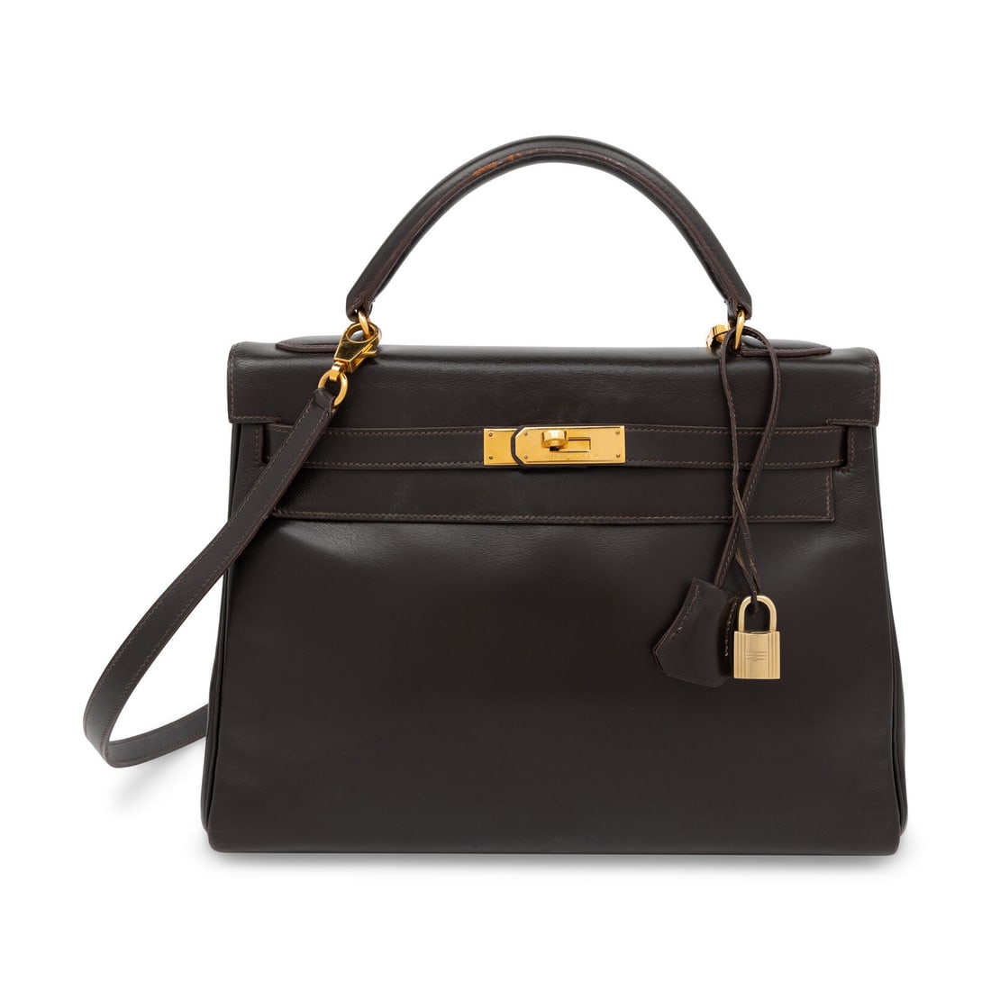 Hermès, Kelly 32 in Ebene Box Leather: Hermès, Kelly 32 in Ebene Box Leather Kelly 32 Retourne in Ebene Box leather with gold-plated hardware. Includes removable strap. Label: Hermès Stamp: U in Circle Date: 1991 Country of Origin: Franc