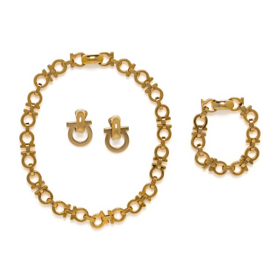 Ferragamo Gancini Parure: Ferragamo Gancini Parure Set of matching chain-link necklace, chain-link bracelet, and pair of ear clips in gold-tone metal "Gancini" design. Label: Ferragamo Date: Late 20th Country of Origin: Italy