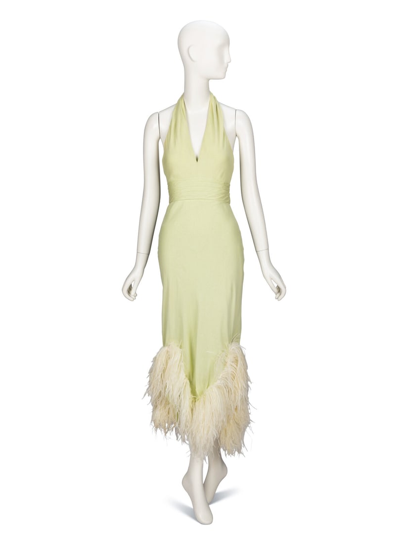 Bill Blass, Pale Green Feathered Halter Dress: Bill Blass, Pale Green Feathered Halter Dress Cocktail dress in mint green silk chiffon with cream ostrich feather trim at hem. Halter neckline with open back; hook-and-eye closures at back of neck. A