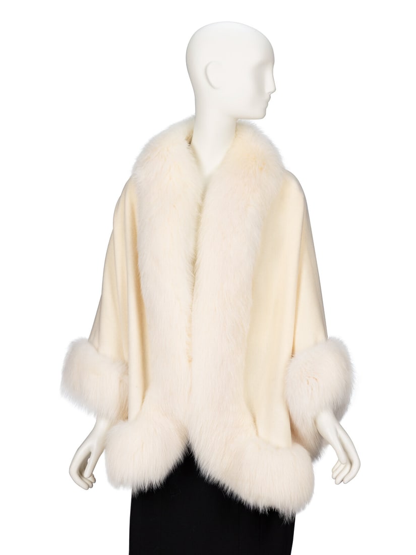 Revillon, Cream Fox Fur & Wool Cape: Revillon, Cream Fox Fur & Wool Cape Open-front cape in cream felted wool with cream/white fox fur trim. Hip-length bodice; wrist-length "sleeves". Rounded hemline. No closures. Unlined. Label: