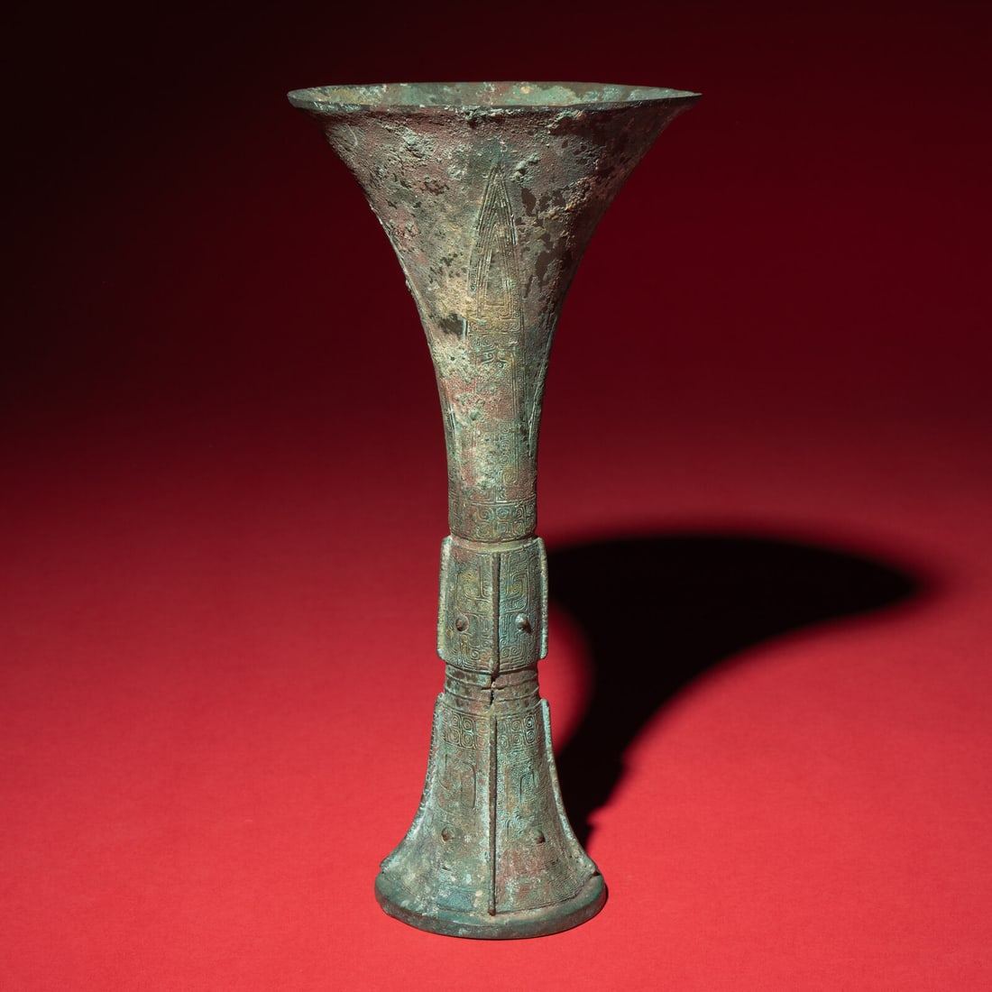 A Chinese Archaic Bronze Gu Vessel, Shang Dynasty: A Chinese Archaic Bronze Gu Vessel, Shang Dynasty 商 青銅觚 Shang Dynasty (12th-11th Century B.C.) Of typical waisted cylindrical form, the central section and spreading base c