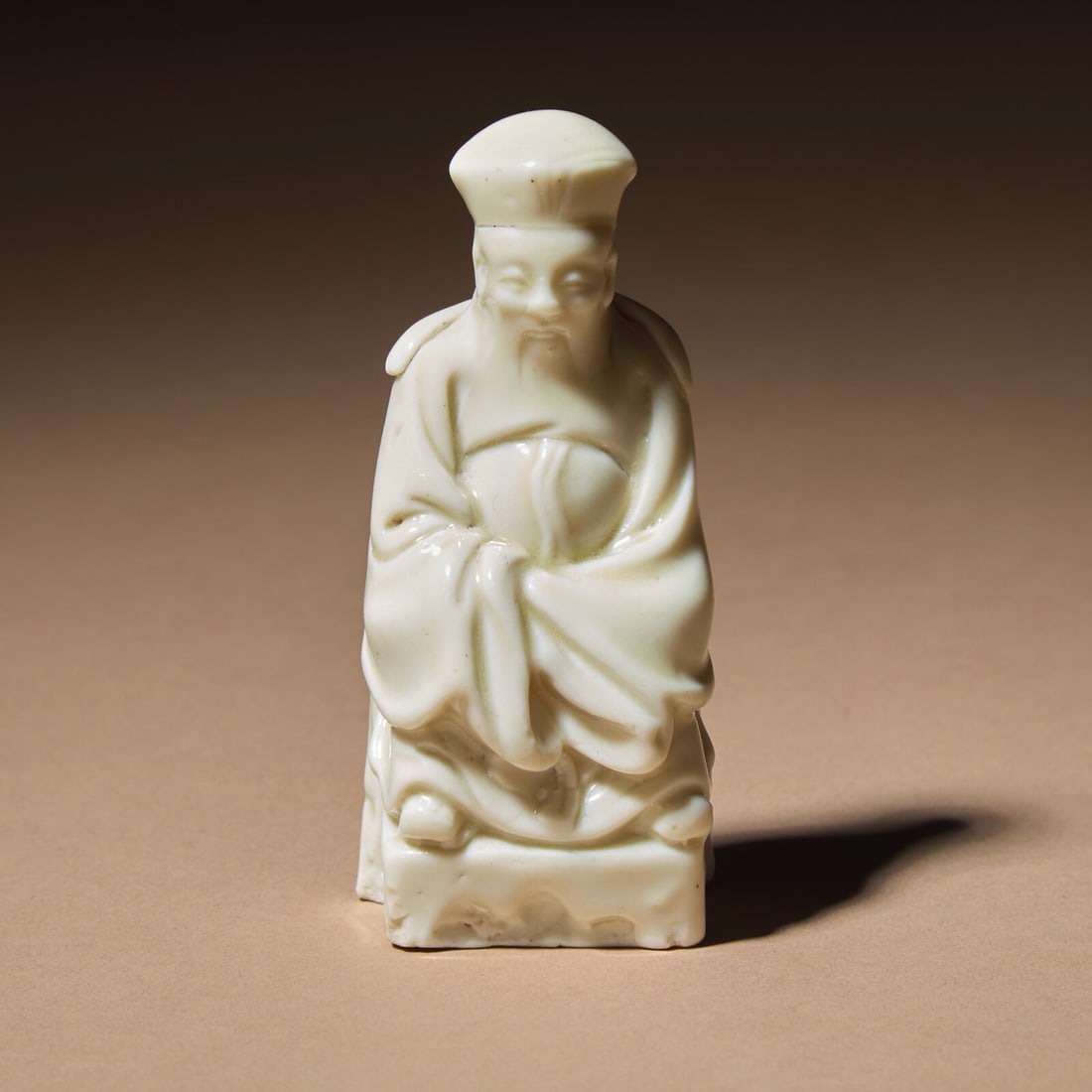 A Chinese Blanc-de-Chine Porcelain Seated Figure of a Dignitary, 17th Century: A Chinese Blanc-de-Chine Porcelain Seated Figure of a Dignitary, 17th Century 清早期 德化白瓷文官坐像 17th Century The sage modeled se