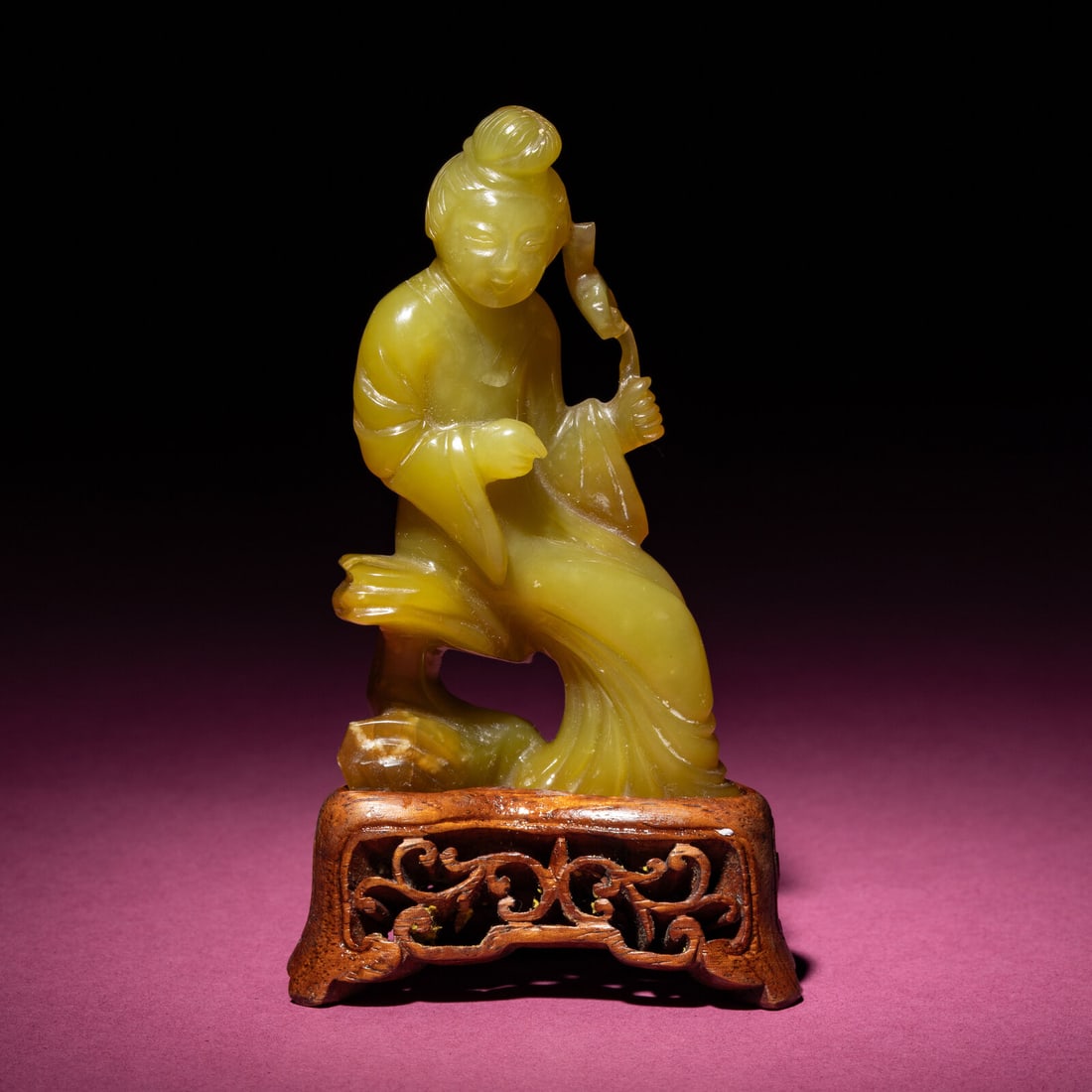 A Chinese Yellow Jade Seated Figure of a Lady, Late Qing Dynasty: A Chinese Yellow Jade Seated Figure of a Lady, Late Qing Dynasty 清晚期 黃玉持蓮仕女 Late Qing Dynasty The softly polished figure is depicted seat
