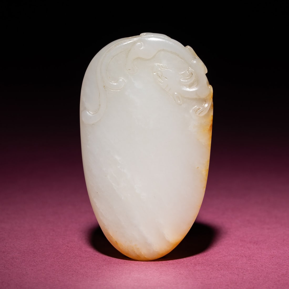 A Chinese Russet and White Jade 'Chilong' Pendant, 18th/19th Century: A Chinese Russet and White Jade 'Chilong' Pendant, 18th/19th Century 清中期 白玉留皮螭龍紋佩 18th/19th Century Of pebble form, the top