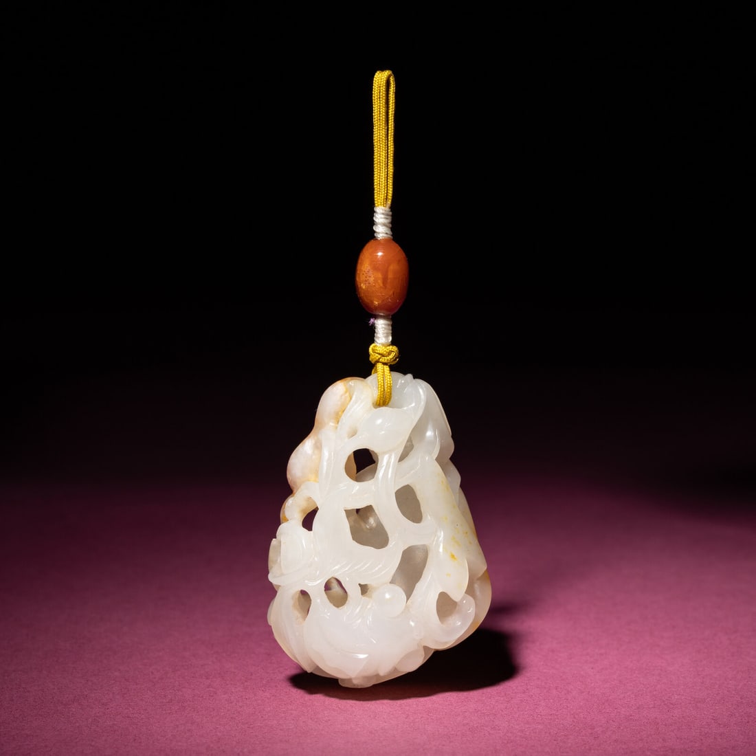 A Chinese Russet and White Jade Reticulated 'Lotus' Pendant, 18th/19th Century: A Chinese Russet and White Jade Reticulated 'Lotus' Pendant, 18th/19th Century 清中期 白玉帶皮鏤雕蓮紋佩 18th/19th Century Of ir