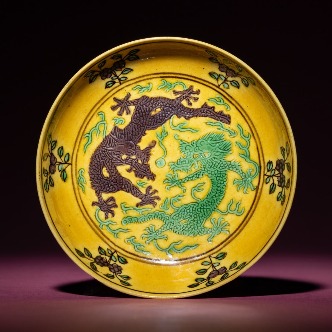 A Small Chinese Yellow Ground Green and Aubergine 'Dragon' Dish, Daoguang Mark and Period: A Small Chinese Yellow Ground Green and Aubergine 'Dragon' Dish, Daoguang Mark and Period 清道光 黃地紫綠彩雙龍戲珠紋Ĵ