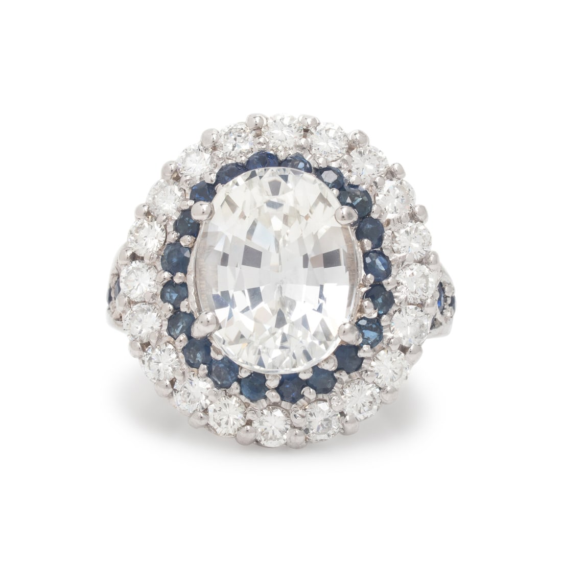 Near Colorless Sapphire, Diamond, and Sapphire Ring: Near Colorless Sapphire, Diamond, and Sapphire Ring Featuring an oval near colorless sapphire weighing approximately 7.80 carats, haloed by round brilliant diamonds weighing approximately 1.40 carats 