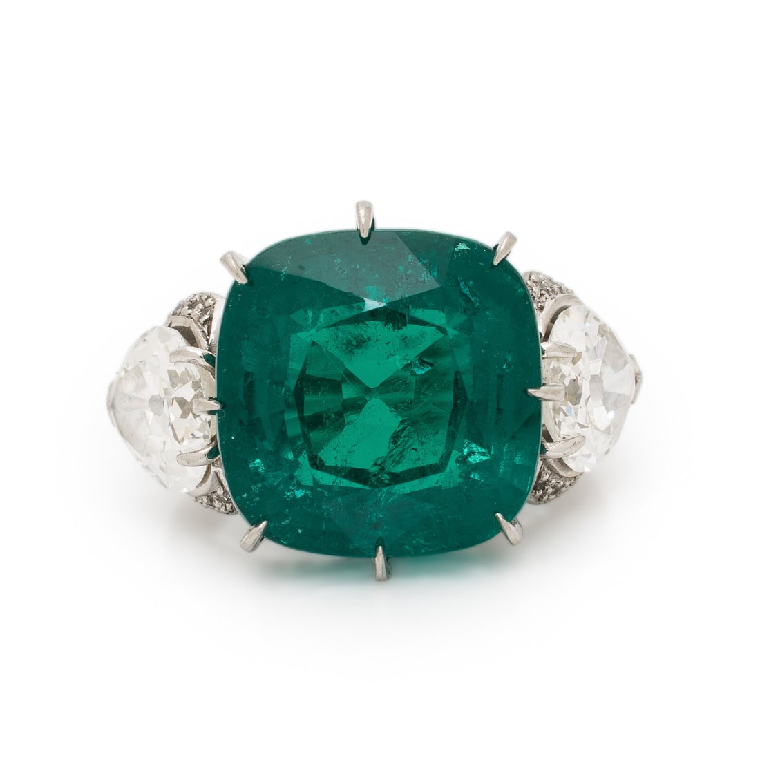 Colombian Emerald, Diamond, and Platinum Ring: Colombian Emerald, Diamond, and Platinum Ring Featuring a cushion mixed cut Colombian emerald weighing approximately 13.50 carats by formula, flanked by two pear shape diamonds weighing approximately 