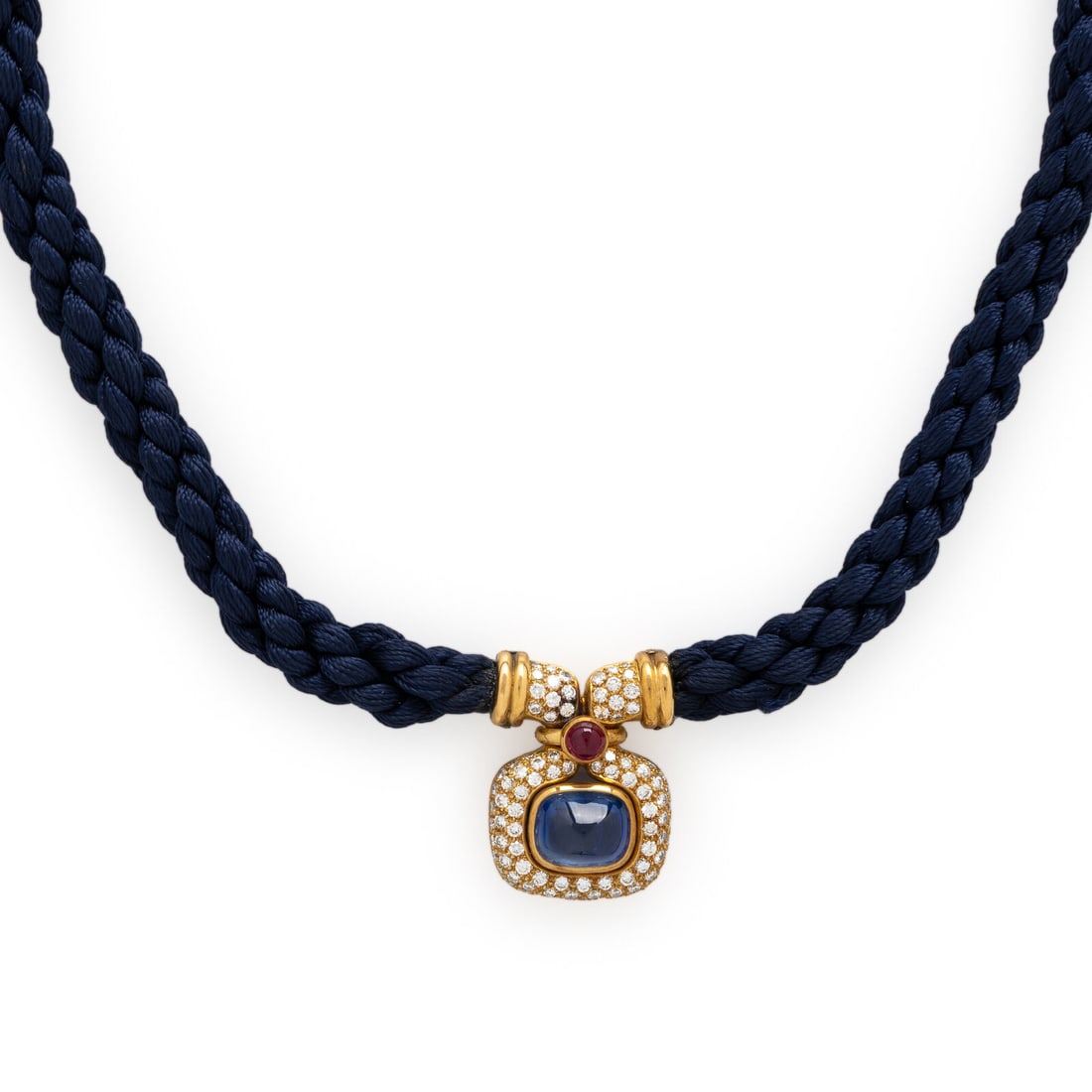 Bulgari, French, Yellow Gold, Sapphire, Diamond, and Silk Cord Necklace: Bulgari, French, Yellow Gold, Sapphire, Diamond, and Silk Cord Necklace The pendant set with a cushion double cabochon cut sapphire weighing approximately 6.25 carats by formula, with a round cabochon