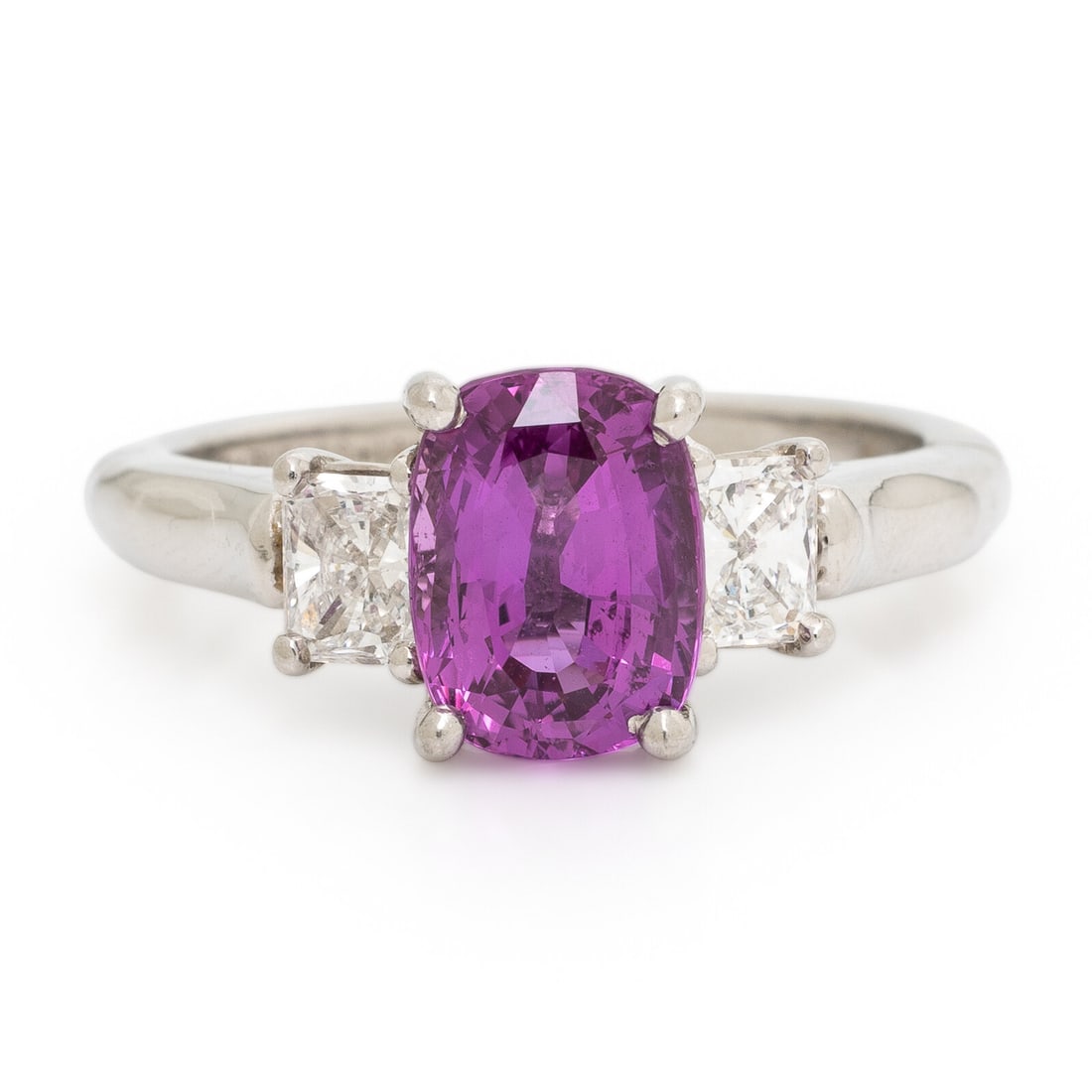 Pink Sapphire and Diamond Ring: Pink Sapphire and Diamond Ring Centering a cushion cut pink sapphire weighing approximately 3.00 carats by formula, flanked by radiant cut diamonds weighing approximately 0.60 carat total. Mounted in