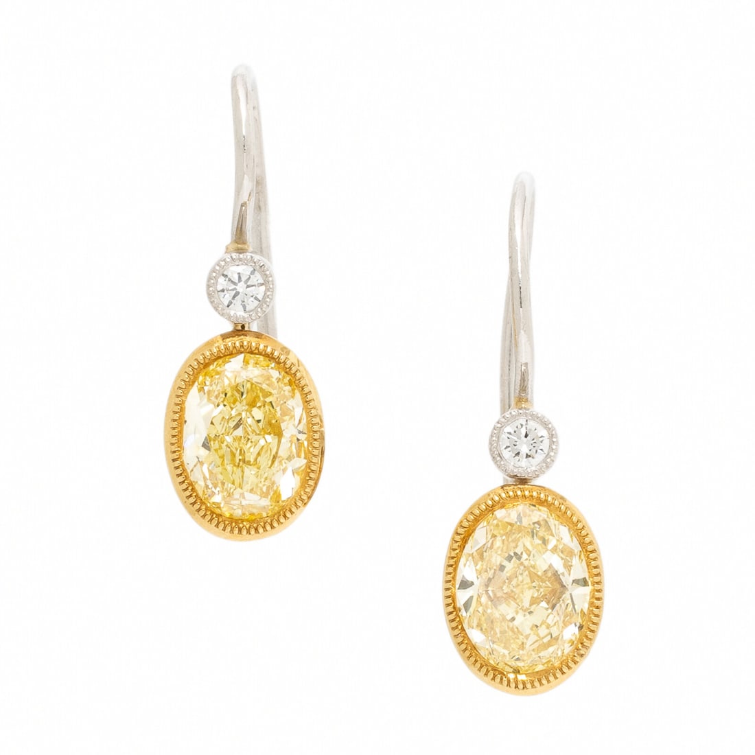 Yellow Diamond, Diamond, Yellow Gold, and Platinum Earrings: Yellow Diamond, Diamond, Yellow Gold, and Platinum Earrings Featuring two oval yellow diamonds (origin of color not tested) weighing approximately 1.30 carats total, bezel-set as drops and suspended f
