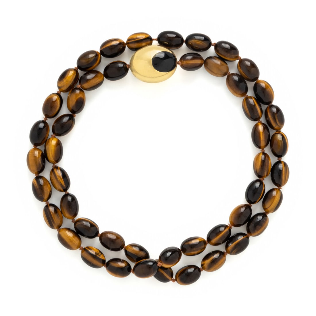 Tiffany & Co., Angela Cummings, Yellow Gold and Tiger's Eye Beaded Necklace: Tiffany & Co., Angela Cummings, Yellow Gold and Tiger's Eye Beaded Necklace A single strand of tiger's eye beads measuring approximately 16.75 x 11.70 - 17.25 x 12.20 mm, accented by a large gold