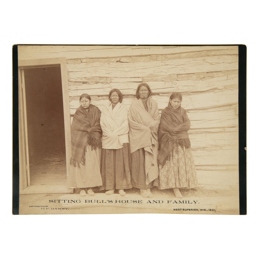 David F. Barry (American, 1854-1934) Sitting Bull's House and Family1891: David F. Barry (American, 1854-1934) Sitting Bull's House and Family1891 albumen photograph 7 x 9 1/4 in. photograph on cardstock mount featuring four subjects standing in front of a wooden structure,