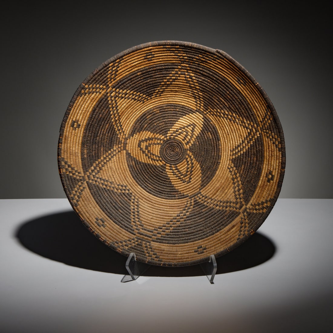 Apache Basket: Apache Basket early 20th century with a floral design and six crosses near the rim height 4 inches x diameter 18-1/2 inches Mrs. Susan Gadpaille Collection This lot is located in Chicago.