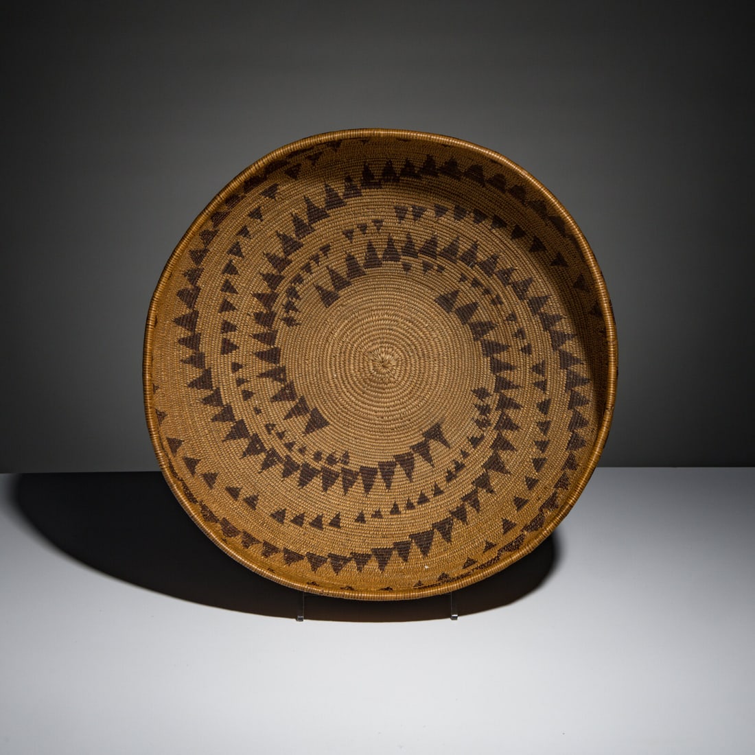 Maidu Basket: Maidu Basket early 20th century repeating bands of various-sized triangles swirl around the body height 6-3/4 inches x diameter 14-1/2 inches This lot is located in Chicago.