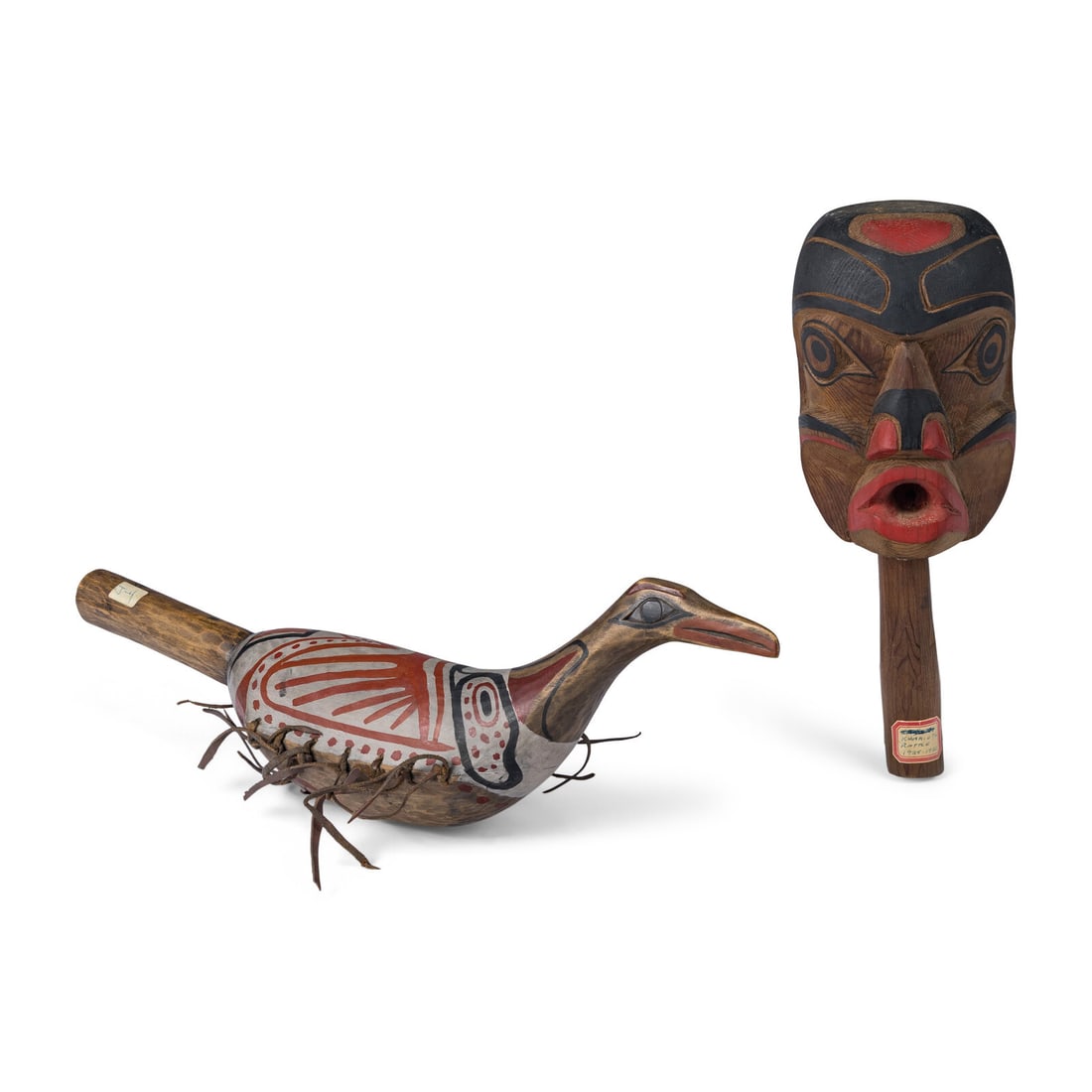 Kwakuitl and Salish Rattles: Kwakuitl and Salish Rattles 20th century lot of 2, includes a rattle with a face; paper label identifies it as "Kwakiutl Rattle, 1925-1930", length 10-3/4 inches a painted raven rattle, length 16 inch
