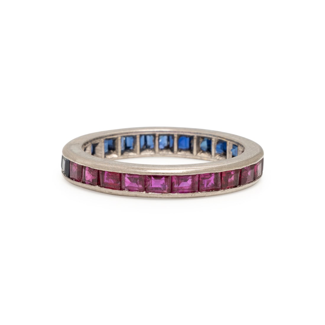 Ruby, Sapphire, and White Gold Eternity Band: Ruby, Sapphire, and White Gold Eternity Band Channel-set rectangular step cut rubies and sapphires. 18 karat white gold. Ring size 7 3/4. Engraved: 18CT. Gross weight: 2.60 dwt.